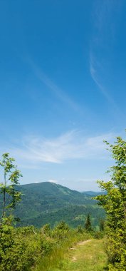 Dağları ve mavi gökyüzü olan güzel bir manzara.
