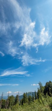 Dağları ve mavi gökyüzü olan güzel bir manzara.