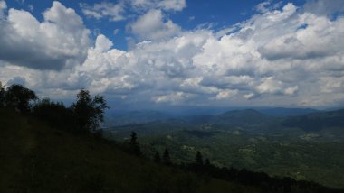 Dağları ve mavi gökyüzü olan güzel bir manzara.