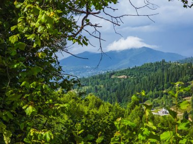 Bulutlu ve mavi gökyüzü olan dağ manzarası.