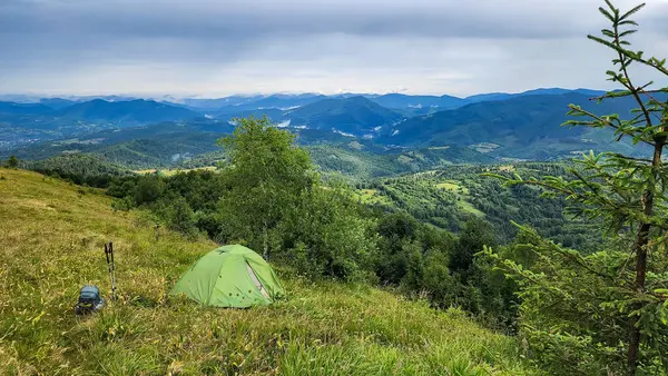 Arka planda turist çadırı ve dağ