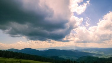 Dağları ve bulutlu gökyüzü olan güzel bir manzara.