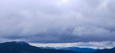 Bulutlu ve mavi gökyüzü olan dağ manzarası