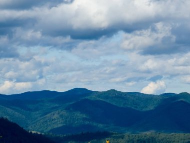 Dağları ve mavi gökyüzü olan güzel bir manzara.