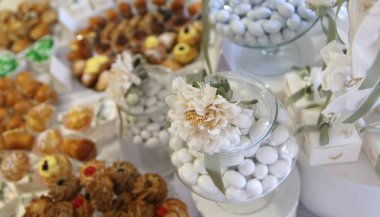 Düğündeki büfede çeşitli tatlı, badem, bisküvi ve kruvasan var.