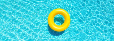 Yellow swimming pool ring float in blue pool water. Summer and vacation concept clipart