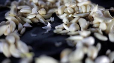 Shot of garlic cloves in a wicker basket on black wooden surface, garlic in wooden basket  4K footage.