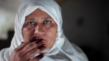 Geleneksel tesettürlü Müslüman bir kadının portresi, beyaz tesettürlü Müslüman bir kadın. Ramazan 2023 konsepti. Elleri dudaklarında, yanaklarında