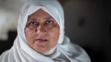 Geleneksel tesettürlü Müslüman bir kadının portresi, beyaz tesettürlü Müslüman bir kadın. Ramazan 2023 konsepti. Merhaba deyip elini sallıyor..