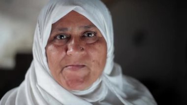 Geleneksel beyaz tesettürlü Müslüman bir kadın dudaklarını oynatıyor ve tuhaf suratlar yapıyor. Müslüman Kadın.