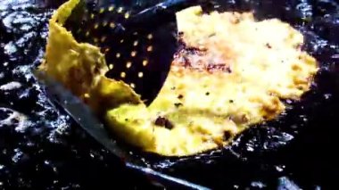 Shot of a man making fresh Malpua or pua, frying them in hot oil. Man-making Malpua.Concept of Ramadan 2023.