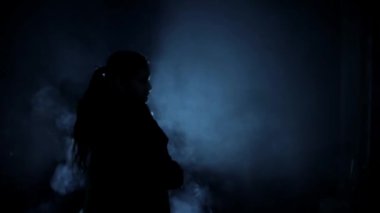 Karanlıkta silahlı bir kadın gangsterin vurulması, dumanlı ve dramatik bir görüntü. Yüksek çözünürlük. 24 FPS.