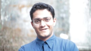 Cinematic shot of a male model smiling happily in front of the camera.