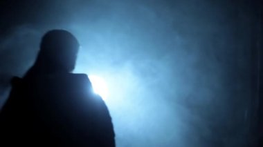 Shot of a female gangster with a gun shooting in the dark, a Cinematic shot with smoke and dramatic light. HD footage. 24 FPS.