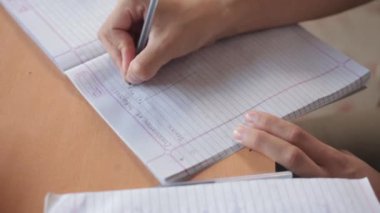 The cinematic close-up shot of handwriting on the page. Man making notes.