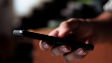 Cep telefonu kullanan bir elin yakın çekimi, cep telefonu kullanan bir genç..