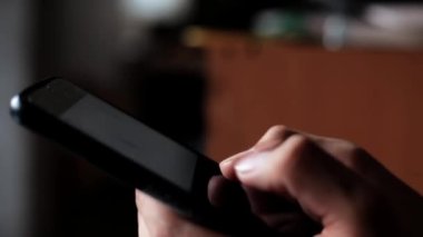 Cep telefonu kullanan bir elin yakın çekimi, cep telefonu kullanan bir genç..