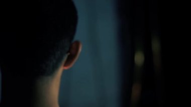 Elinde meşale olan bir çocuğun karanlıkta arka planda şüpheli bir şeyle yürüdüğü yakın plan bir fotoğraf. Yüksek çözünürlük. Sinematik çekim.