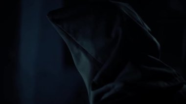 Bir adamın başka bir adamın (rehine) yüzünü ortaya çıkarırken, sandalyeye bağlı ve ona vururken, karanlık, dramatik bir ışık. Hd görüntüleri.