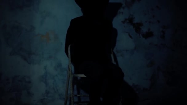 顔を覆う黒い布で椅子に座っている男の映画撮影 そして彼の手が縛られていました 暗い劇的な光 映像は — ストック動画