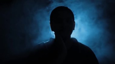 Bir rehinenin, karanlık bir ortamda otururken, bir sandalyeye bağlanmış, dumanlı, yaratıcı ışıklarla çekilmiş yakın plan çekimleri. Yüksek çözünürlük. Kullanımı kolay.