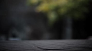 Siyah bir yüzey üzerinde bokeh arka planı olan bir bardak suyun sinematik çekimleri..