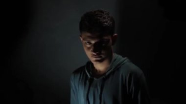 Karanlık, gizemli bir odada birbirini yumruklayan iki adamın görüntüsü..