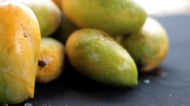 24 FPS HD çözünürlüklü sinematik bebek çekimine sahip siyah bir zemin üzerinde popüler Kesar Kari veya Kesar Mango aam.