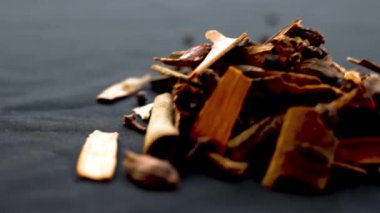 Siyah bir yüzey üzerinde en çok kullanılan ham Hint baharatlarının yakın plan çekimi, kakule, tarçın çubuğu, karabiber, yıldız anason, karanfil, vb..