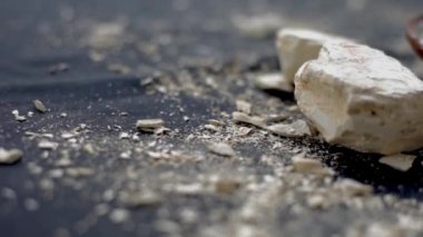 Multani mitti ya da Fuller 'in toprağının siyah bir yüzey üzerindeki yakın çekim görüntüsü ve yüz maskeleri ve doğal olarak parlayan cilt için yüz maskeleri olarak kullanılan çamur bir kaseye yapıştırılması. 24FPS 'te HD görüntüler.