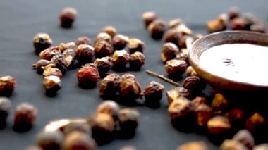 Siyah renkli bir yüzey üzerinde Sapindus mukorossi, sabun veya areetha çekimleri ve saç bakımı ve kozmetik ürünleri için kullanılan mayalanmış suyu..