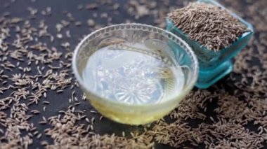 Kimyon tohumlarının yakın plan sineması veya Zeera veya Jeera (Cuminum cyminum) cam bir kâse içinde çıkarılan suyla birlikte 24 FPS görüntüleridir.