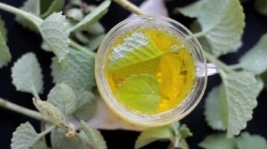 Ajwain 'in HD görüntüsü, bitkisel çayıyla birlikte parlak, siyah bir yüzeye yakın bir çay fincanında ayrılıyor. Trachyspermum ammi ya da Caraway 'in yüksek kaliteli görüntüleri ve soğuk algınlığı için kullandığı çay..