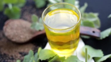 Ajwain 'in yüksek çözünürlüklü görüntüsü, parlak siyah bir yüzey üzerinde çıkarılmış suyuyla birlikte ayrılır. Trachyspermum ammi ya da Caraway tohumlarının yüksek kaliteli görüntüleri ve soğuk algınlığı ve grip için kullandığı su..