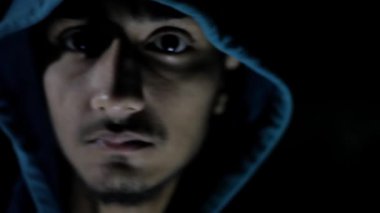 Kapüşonlu bir çocuğun karanlıkta yürürken çekilmiş yakın plan fotoğrafı. Hayaletlerden korkmuş ve korkmuş görünüyor. 24FPS 'te HD görüntüler. Korku filmi gibi..