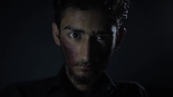 暗い謎の部屋でカメラに近づく彼の顔に小さな血で負傷者の低角度ショット Hdの映像 — ストック動画