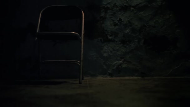 金属座椅在其自身表面上运动的轮廓 异乎寻常的恐怖片一般的椅子移动或拉扯的镜头 黑暗的阁楼房间 只有一个光源和一个金属椅子高清镜头 — 图库视频影像