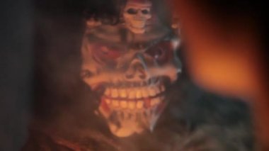 Yüz yüze maskeli korkunç bir adamla bir adamın sinematik çekimi, dumanla yakın çekim. 24 FPS görüntü.. 