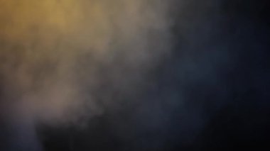 Karanlıkta ateş eden silahlı bir adamın yaratıcı görüntüsü. Karanlık ve dumanlı bir ortamda elinde ateşli bir silahla dolaşan bir suçlunun HD görüntüleri..