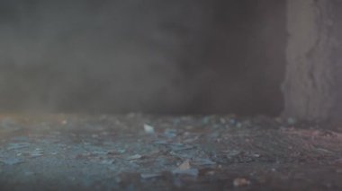 Bir kız döküntülerle dolu bir zeminde hava durumu ayakkabısı giyerek yürüyor.