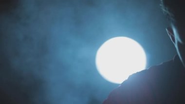 Filmlerdeki gibi kırmızı gömlekli bir adam gizli bir görev için hazırlanıyor silahlarını ve bıçaklarını yaratıcı dramatik ışıklandırma tekniği olan HD - 24 Fps - Prores