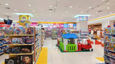 Balikpapan, Endonezya - 26 Temmuz 2024: Parlak ışık altında, masa oyunları ve oyun setlerinden lüks oyuncaklara ve plastik arabalara kadar çeşitli oyuncakların sergilendiği canlı bir oyuncakçı koridorunun geniş görünümü. Çeşitli çocuk oyuncakları almak için mükemmel..