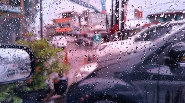 Kalabalık bir şehir caddesini bulanık gören bir araba camına yağmur damlaları, sakinlik ve yansıma hissi veriyor. Yağmurlu günler için mükemmel ya da tatlı temalı hüzünlü ve türkü şarkıları eşliğinde.