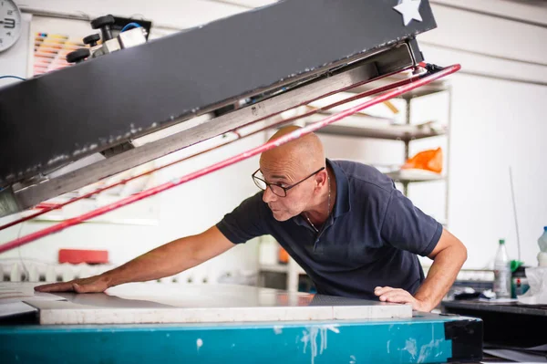 Nyomdában Egy Tapasztalt Technikus Dolgozik Egy Szitanyomógépen Gyártási Munka Nyomtatás — Stock Fotó