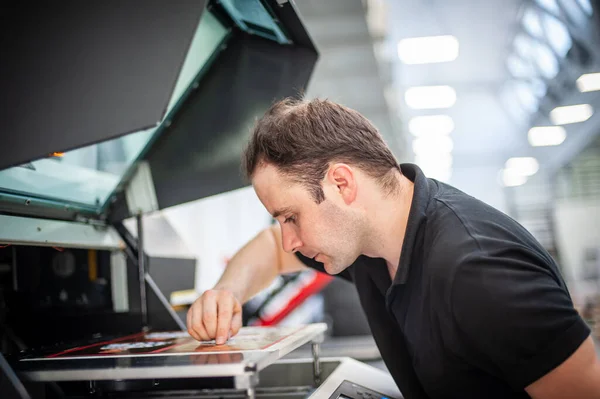 在印刷厂 一位经验丰富的技术员在一台Uv打印机上工作 生产工作 检查印刷质量 — 图库照片