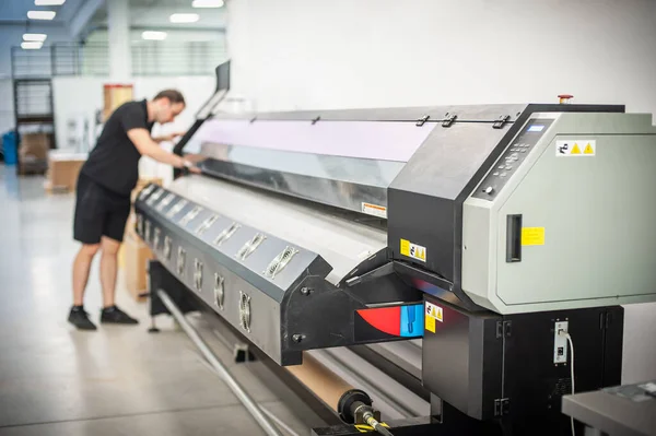 在印刷厂 一位经验丰富的技术员在一台Uv打印机上工作 生产工作 检查印刷质量 — 图库照片