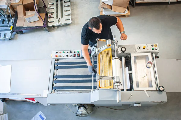인쇄소에서는 경험있는 기술자가 자외선 프린터로 작업하고 있습니다 — 스톡 사진