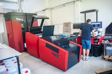 Matbaada modern büyük baskı makinesi olan profesyonel bir işçi. Yazdırma endüstrisi konsepti.