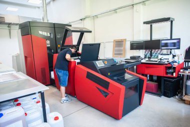 Matbaada modern büyük baskı makinesi olan profesyonel bir işçi. Yazdırma endüstrisi konsepti.