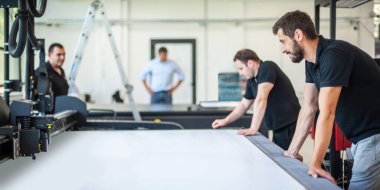 Profesyonel grafik teknisyenleri, bir matbaa ve matbaada çok çeşitli makinelerle çalışıyorlar.